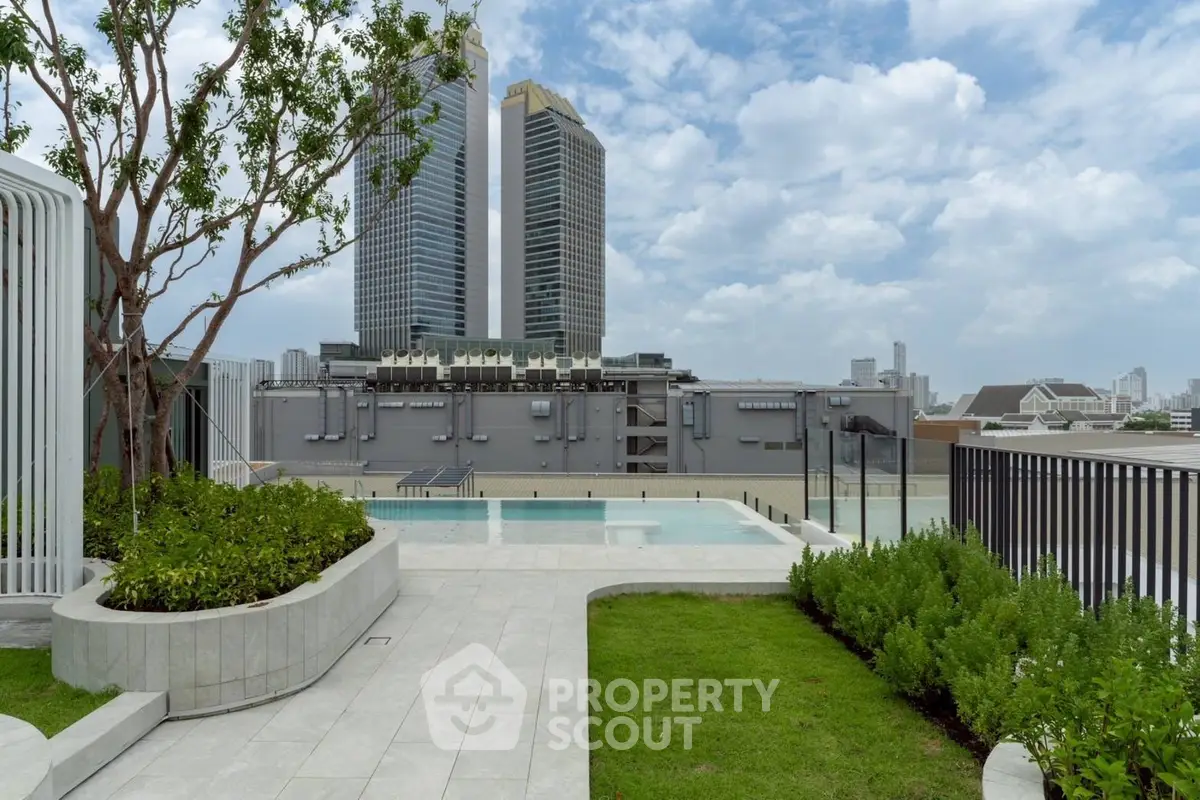 Stunning rooftop pool with city skyline views and lush greenery.