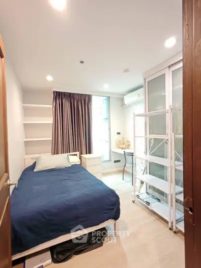 Cozy bedroom with modern decor, featuring a comfortable bed, ample storage, and natural light from a large window.