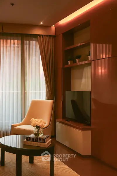 Elegant living room with modern TV unit and cozy armchair by the window.