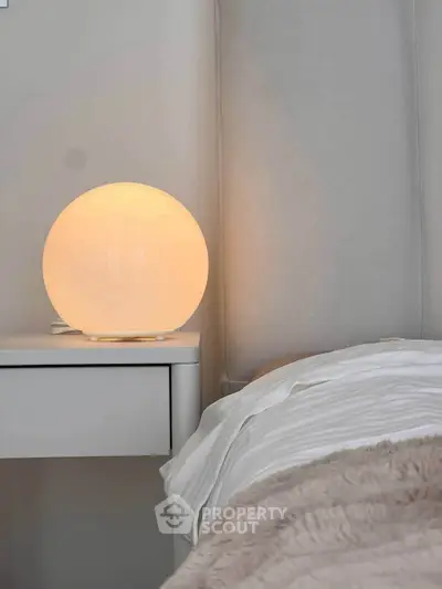Cozy bedroom with modern bedside lamp and soft bedding