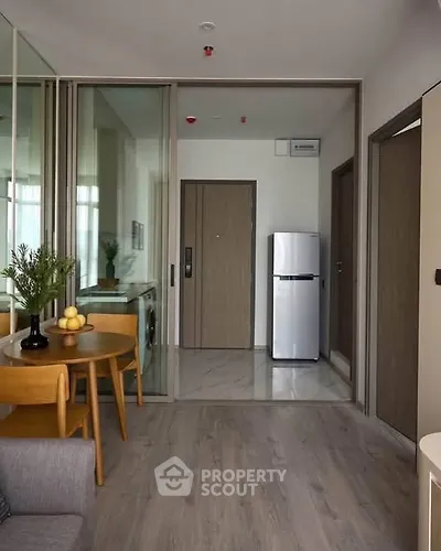 Modern apartment interior with open layout, featuring a cozy living area and sleek kitchen appliances.