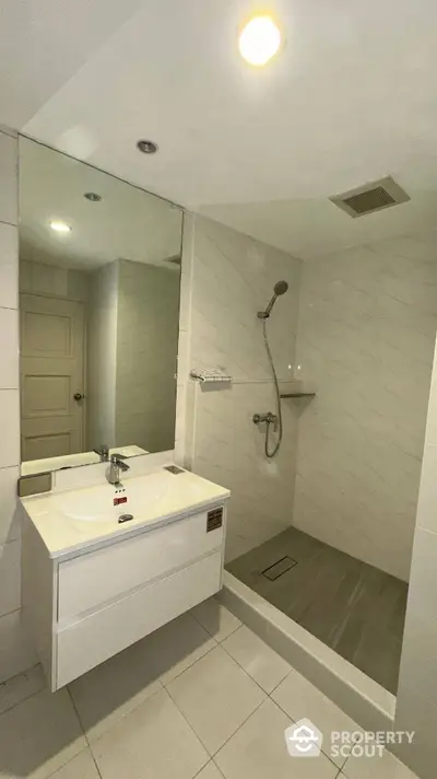 Modern bathroom with sleek shower and vanity in contemporary home.