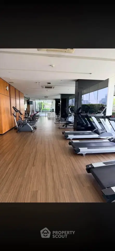 Spacious modern gym with treadmills and exercise equipment in a luxury residential building.