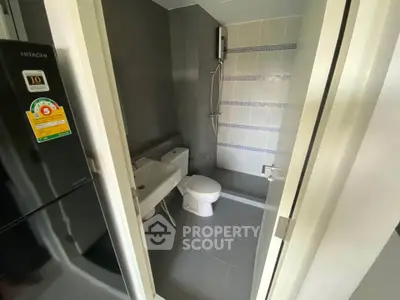 Modern bathroom with sleek fixtures and a compact design, featuring a shower and toilet.