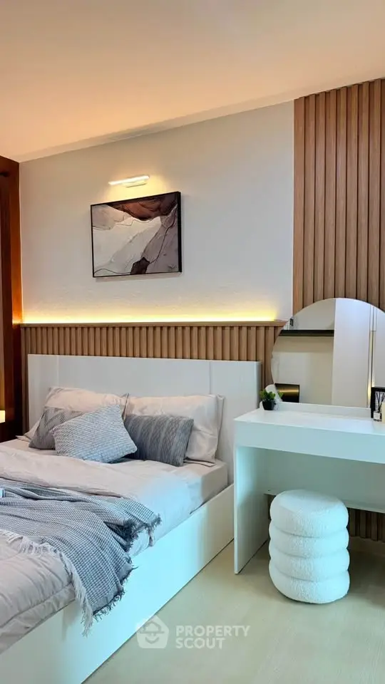 Modern bedroom with stylish decor and cozy ambiance, featuring a sleek vanity and elegant lighting.