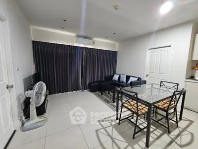 Spacious modern living room with sleek furniture and dining area, perfect for comfortable living.