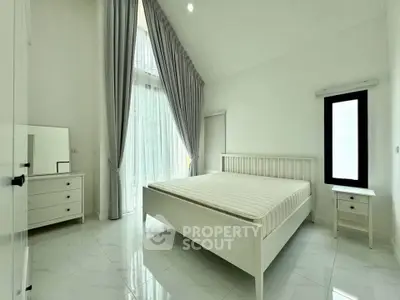 Spacious modern bedroom with high ceilings and elegant curtains in a bright, minimalist design.