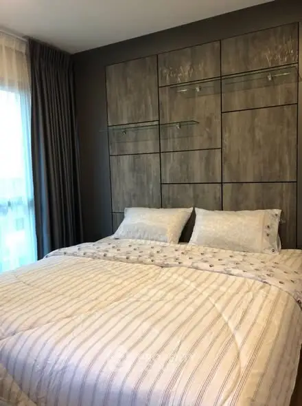 Cozy bedroom with modern decor and large window for natural light.