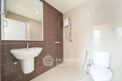 Modern bathroom with sleek fixtures and brown accent wall