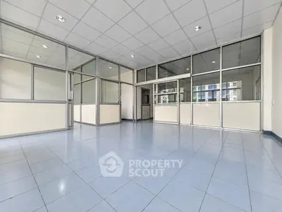 Spacious office space with glass partitions and tiled flooring, ideal for modern business setups.