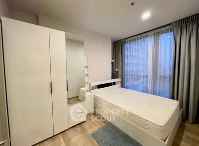 Modern bedroom with large window and minimalist furniture in a stylish apartment.