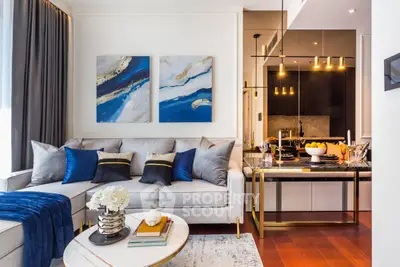 Luxurious modern living room with elegant decor and open kitchen layout, featuring stylish furniture and vibrant artwork.