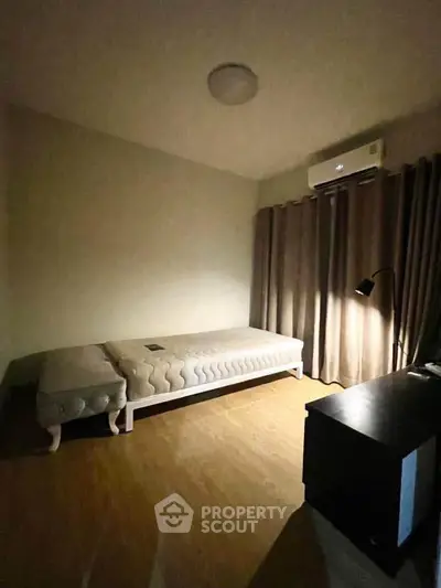Cozy bedroom with single bed, air conditioning, and soft lighting.