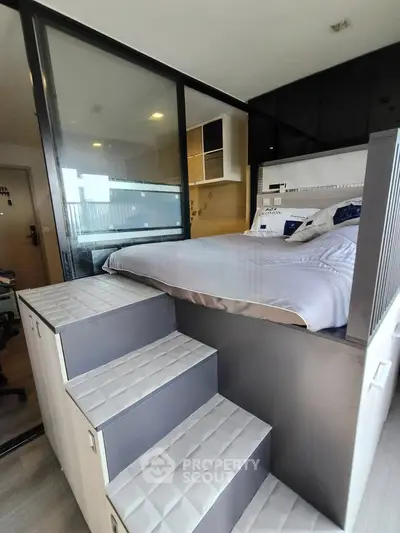Modern bedroom with elevated bed and sleek storage solutions in a stylish apartment.