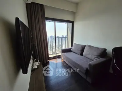 Cozy living room with city view, featuring a modern sofa and wall-mounted TV, perfect for urban living.