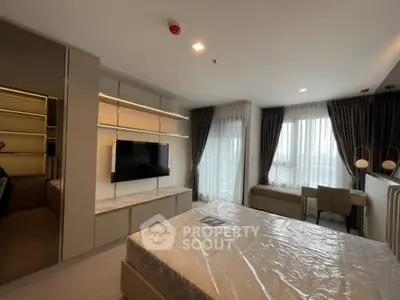 Modern bedroom with large windows and stylish decor in a luxury apartment.