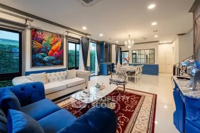 Luxurious living room with elegant decor and spacious layout, featuring plush sofas and vibrant artwork.