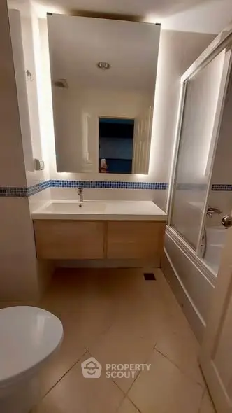 Modern bathroom with sleek vanity and bathtub in a stylish apartment.