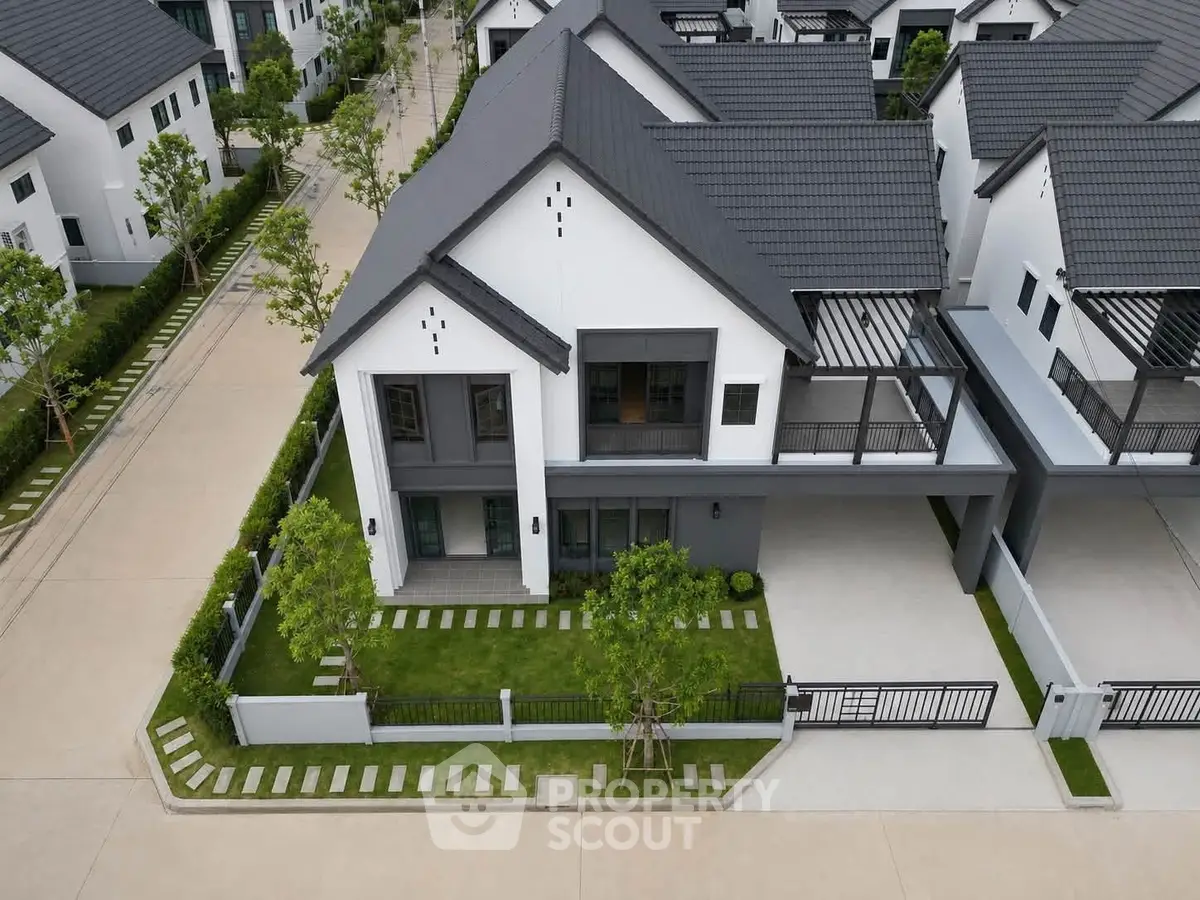 Modern two-story house with sleek design and spacious driveway in a serene neighborhood.