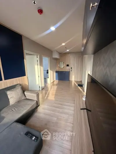 Modern living room with sleek design, wooden flooring, and natural light, perfect for contemporary urban living.