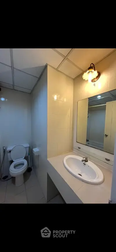 Modern bathroom with sleek fixtures and bright lighting, featuring a spacious vanity and contemporary design.