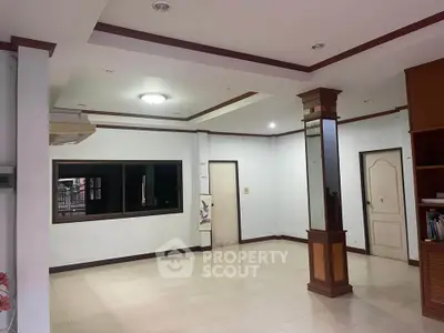 Spacious living room with elegant ceiling design and large window for natural light.