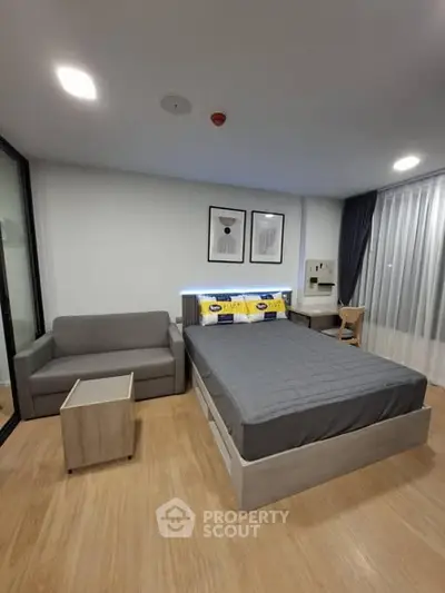 Modern bedroom with stylish decor and cozy seating area, perfect for relaxation.