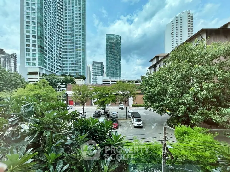 Stunning urban view from a high-rise building with lush greenery and city skyline.
