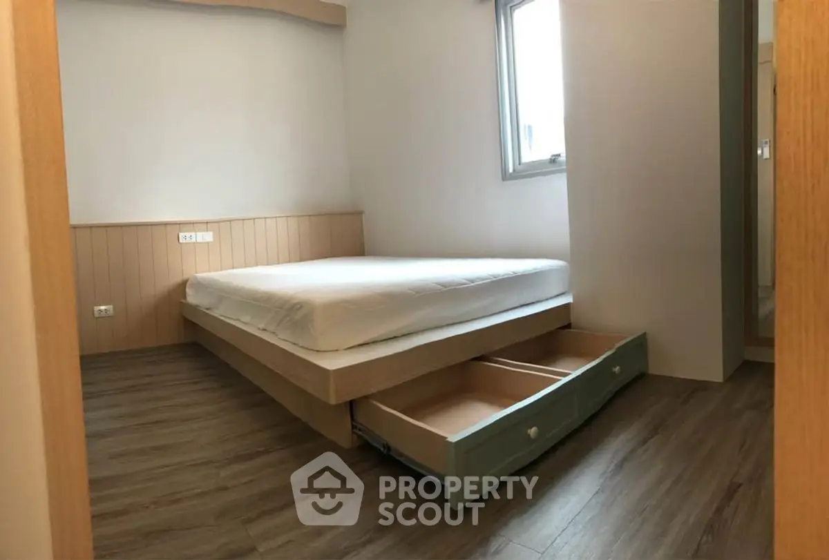 Cozy bedroom with wooden flooring and built-in storage bed