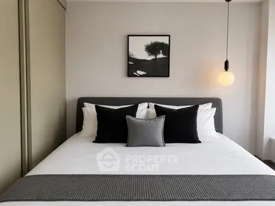 Modern bedroom with stylish decor and cozy bedding in a contemporary apartment.