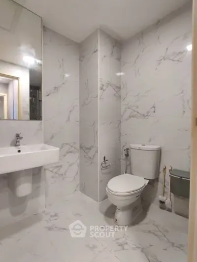 Modern bathroom with marble tiles and sleek fixtures in a contemporary apartment.
