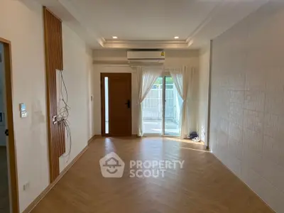 Spacious empty living room with wooden flooring and large window