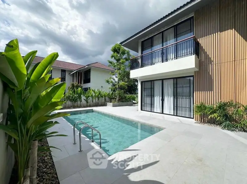 Modern two-story house with private pool and lush garden, perfect for luxury living.