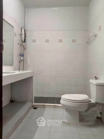 Spacious bathroom with modern fixtures and tiled walls.