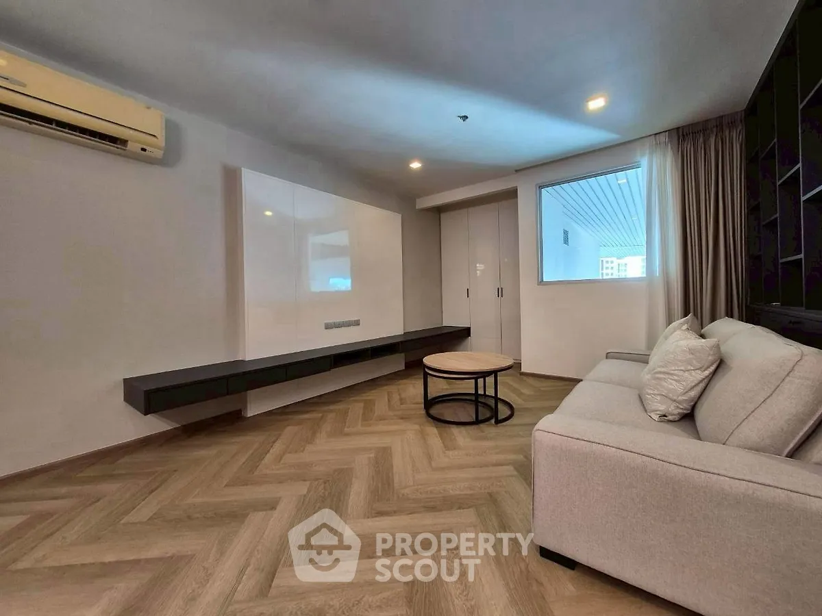 Modern living room with herringbone flooring and sleek furniture