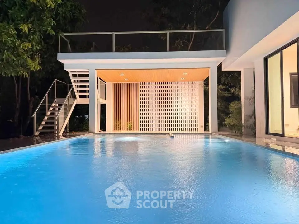 Luxurious modern home with stunning illuminated pool and stylish architecture at night.