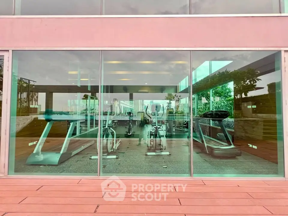 Modern gym with state-of-the-art equipment and large glass windows offering scenic views.