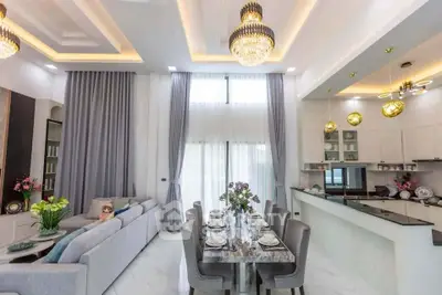 Luxurious open-plan living and dining area with elegant chandeliers and modern kitchen.