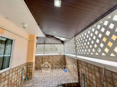 Spacious tiled balcony with lattice privacy screens and wooden ceiling, perfect for outdoor relaxation.