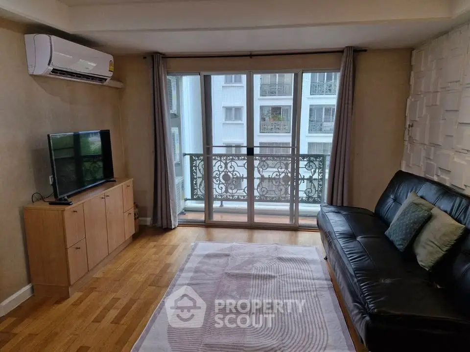 Modern living room with balcony view, air conditioning, and stylish decor.