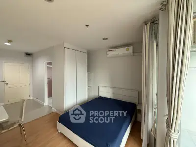 Modern bedroom with minimalist design, featuring a comfortable bed, built-in wardrobe, and air conditioning.