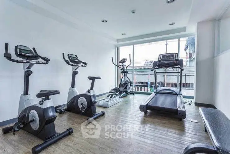 Modern gym with exercise bikes and treadmill in a bright, spacious room.