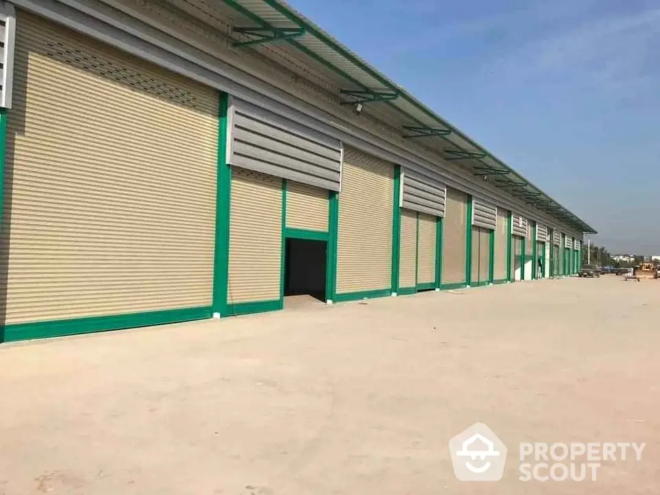 Spacious industrial warehouse with large roller doors and ample outdoor space.