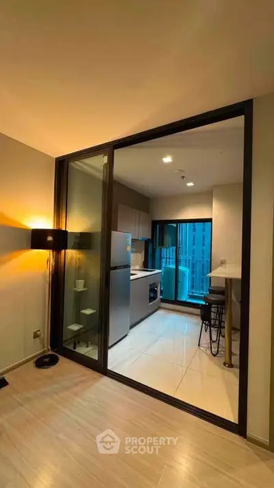 Modern apartment with open kitchen and stylish lighting, featuring a cozy dining area and city view.