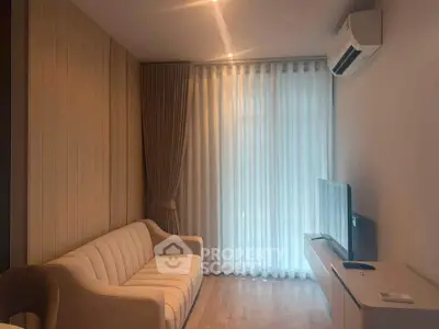 Modern living room with elegant sofa and wall-mounted TV, featuring soft lighting and air conditioning.