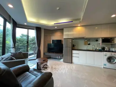 Spacious modern living room with open kitchen, featuring large windows and lush greenery view.