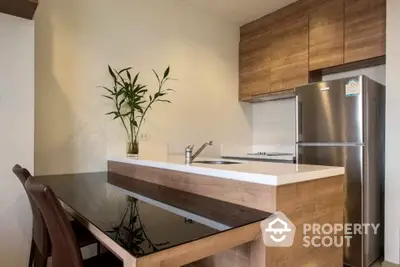 Modern kitchen with sleek wooden cabinets and stainless steel fridge