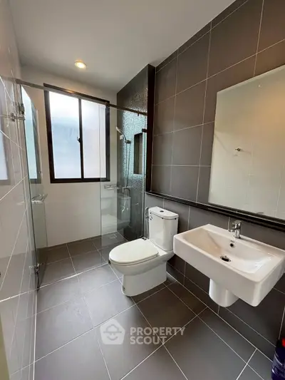 Modern bathroom with sleek fixtures and large window for natural light.