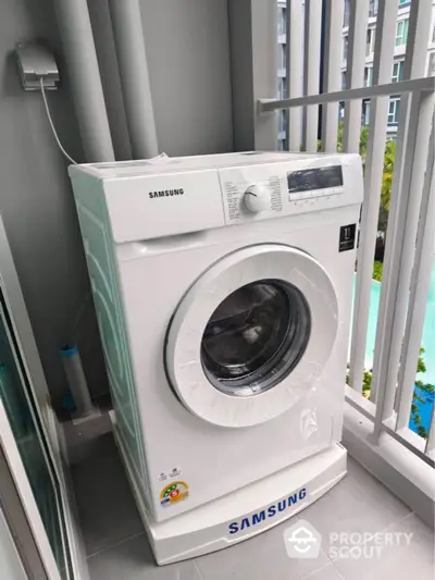 Modern washing machine on apartment balcony with city view