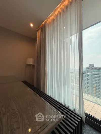 Modern apartment with floor-to-ceiling windows and city view from balcony.